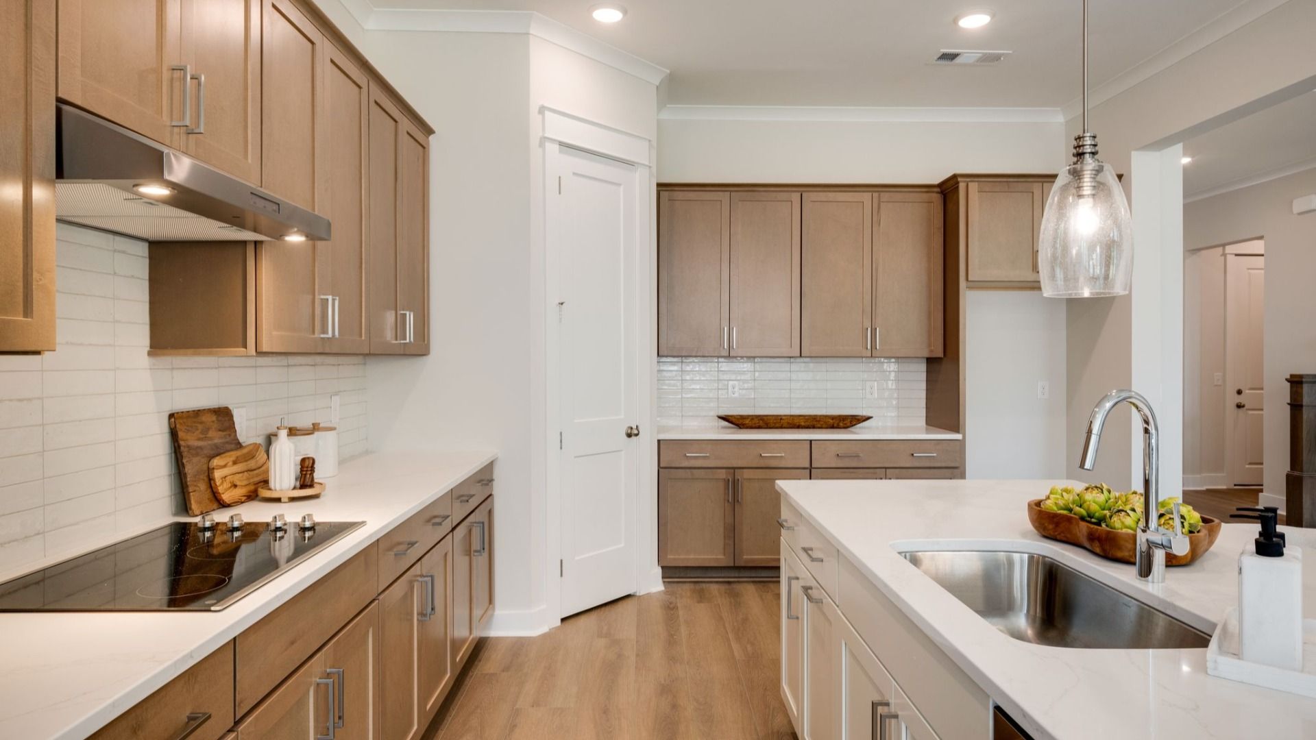 Sink and dishwasher paired with kitchen island next to staircase