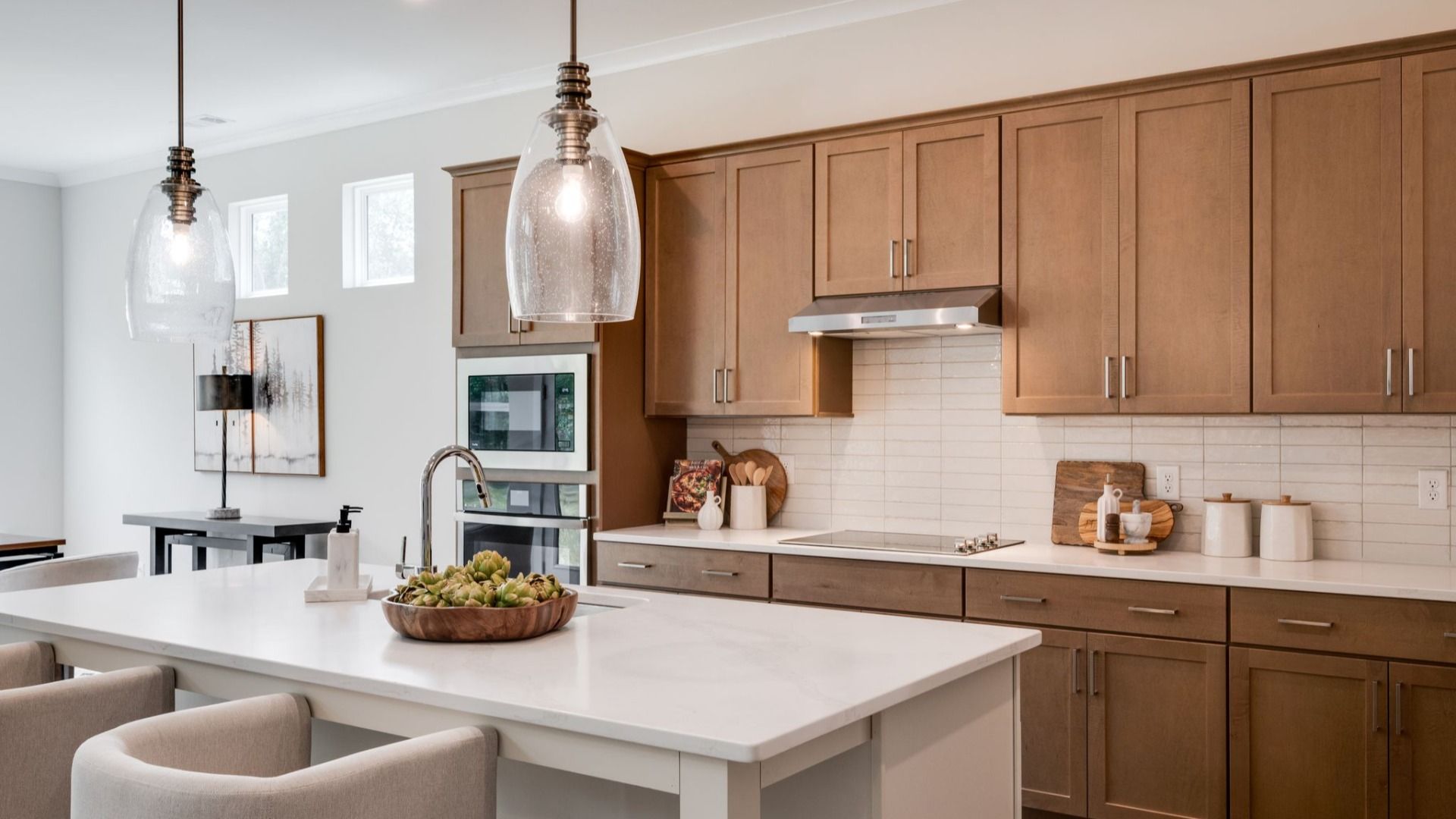 Hanging lights over kitchen island next to versatile living space