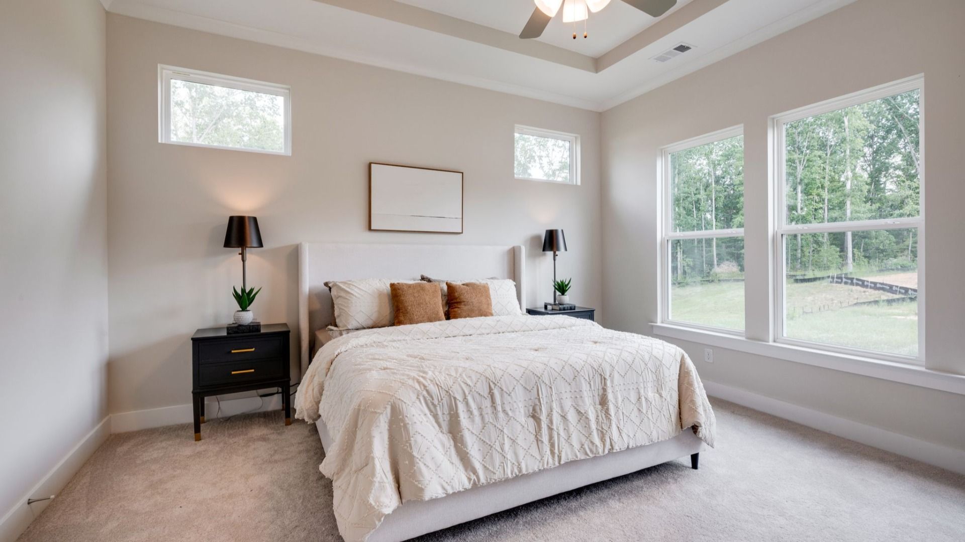 Primary bedroom with trey ceilings and sizeable windows connected to bathroom and walk-in closet