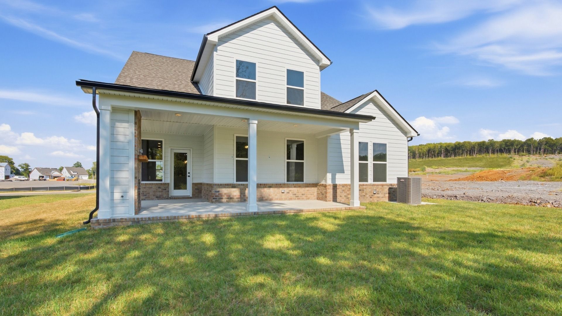 Two-story home with back porch and view of community