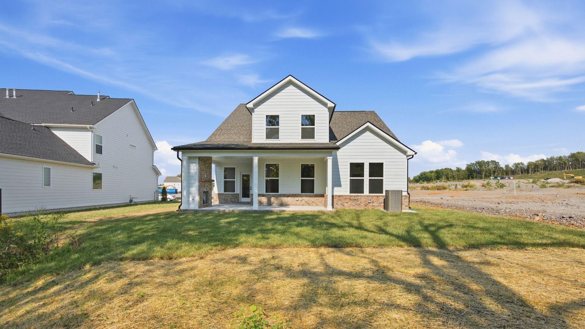 Two-story home with back porch and view of community