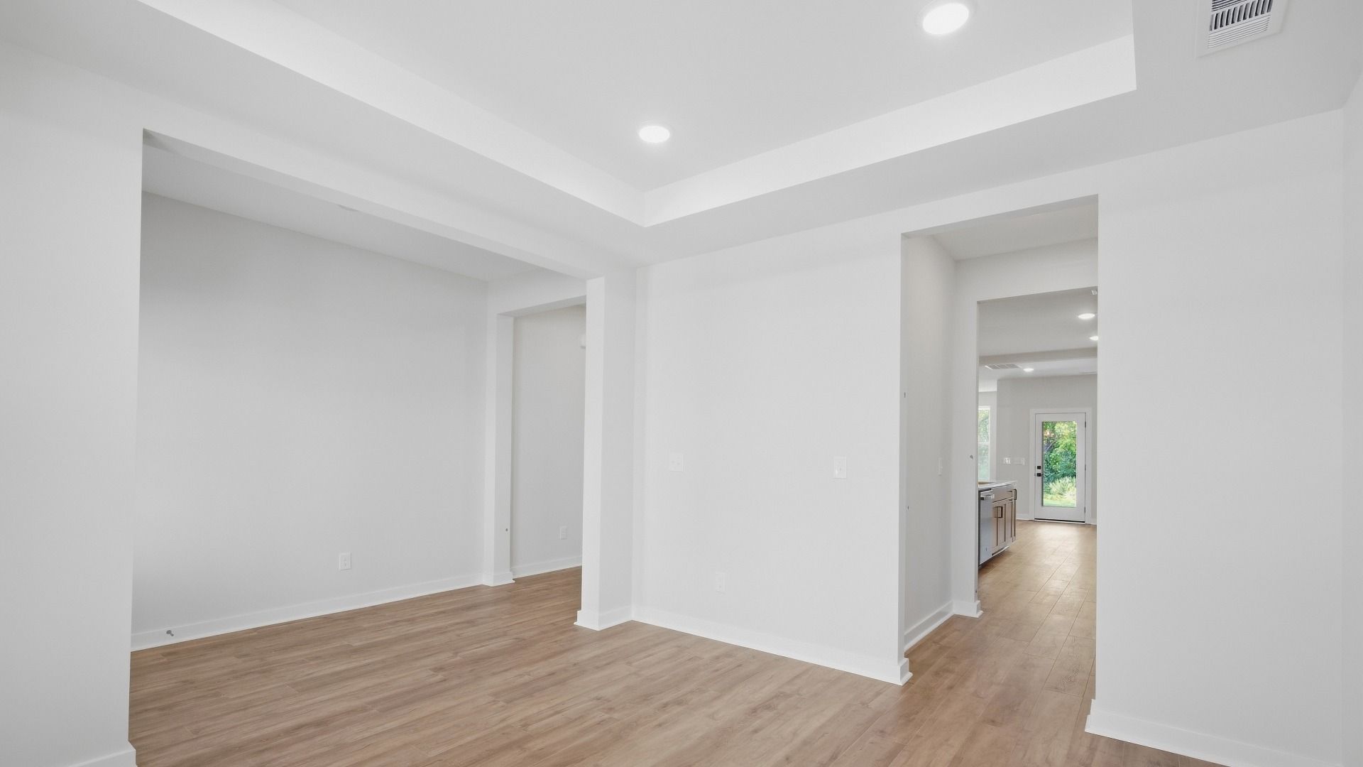 Versatile living space right next to front door entrance with elevated trey ceilings