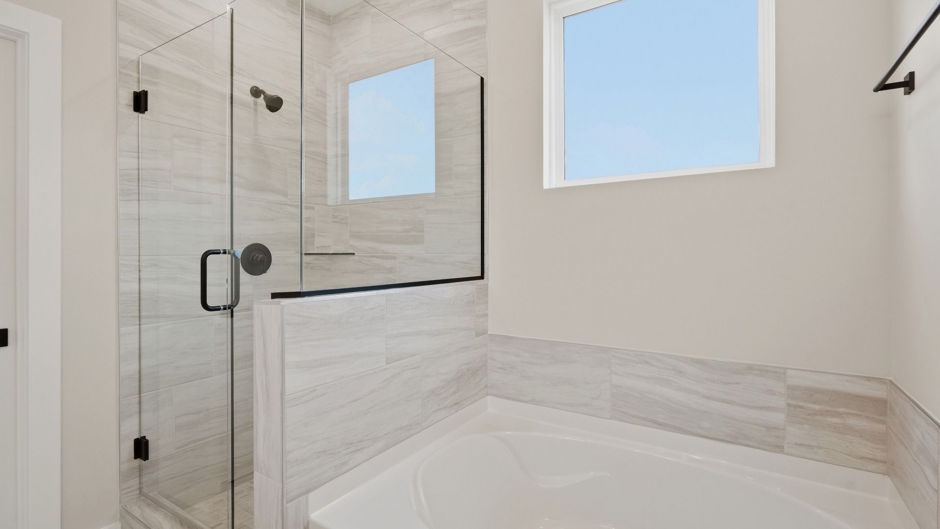 Bathtub and shower with windows above