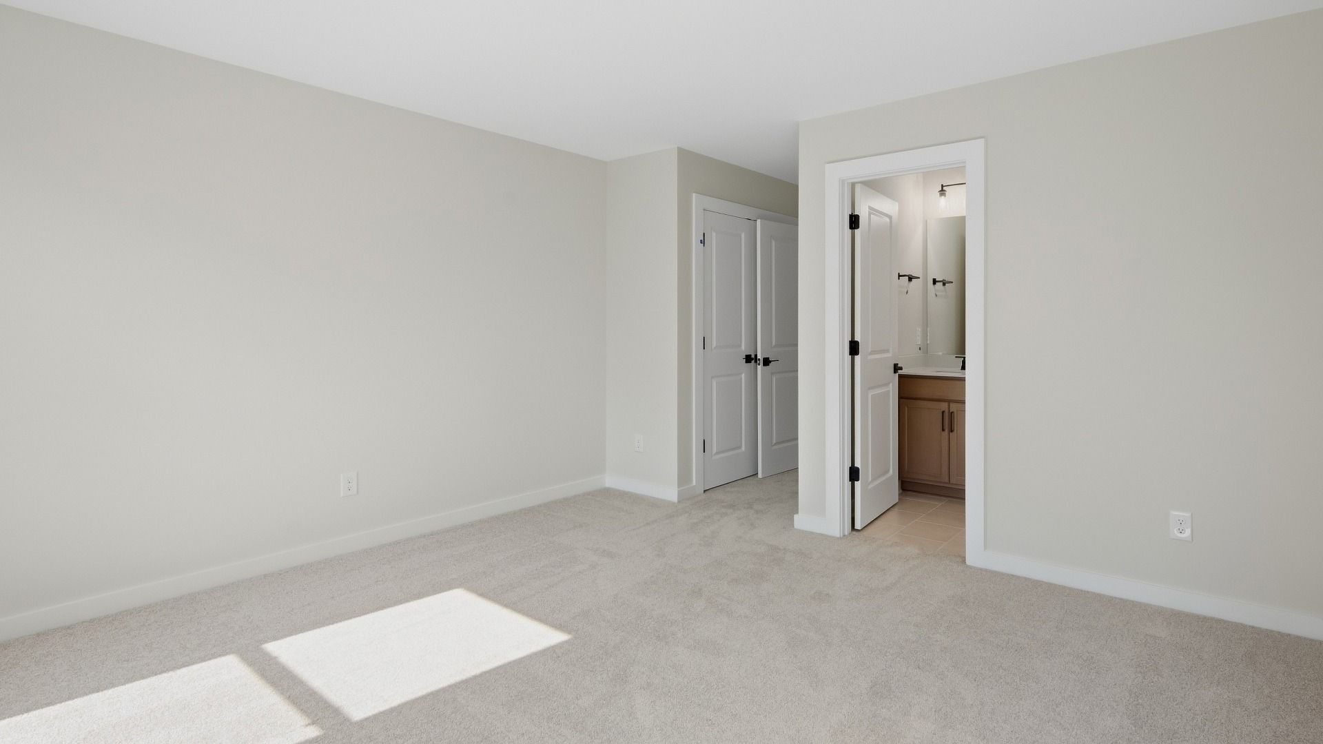 Upstairs secondary bedroom with connected bathroom and double-door closet