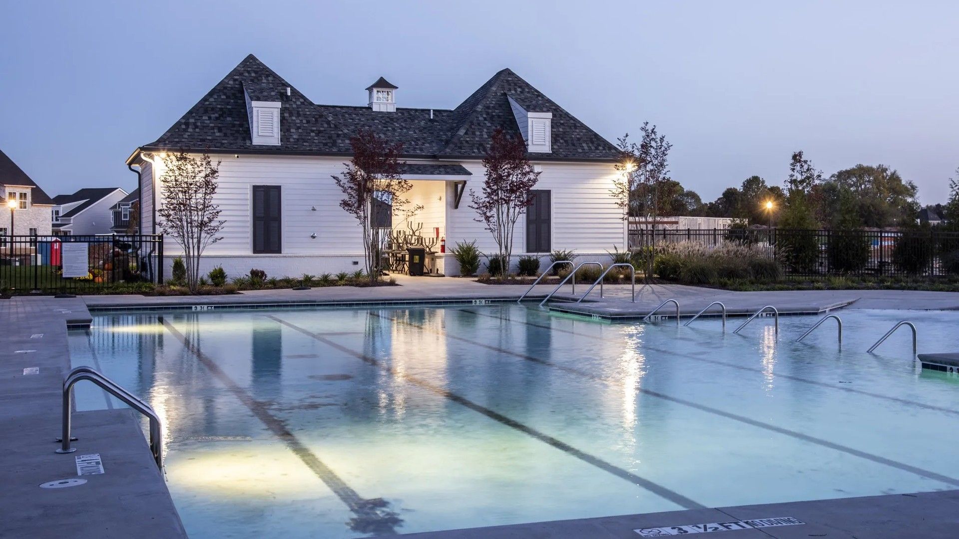 Large community pool with nighttime lighting