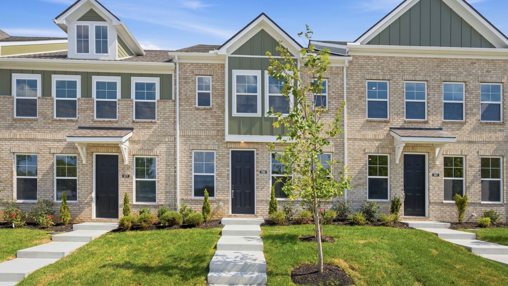 Beautiful two-story townhome with green accents and black door in Lebanon, Tennessee