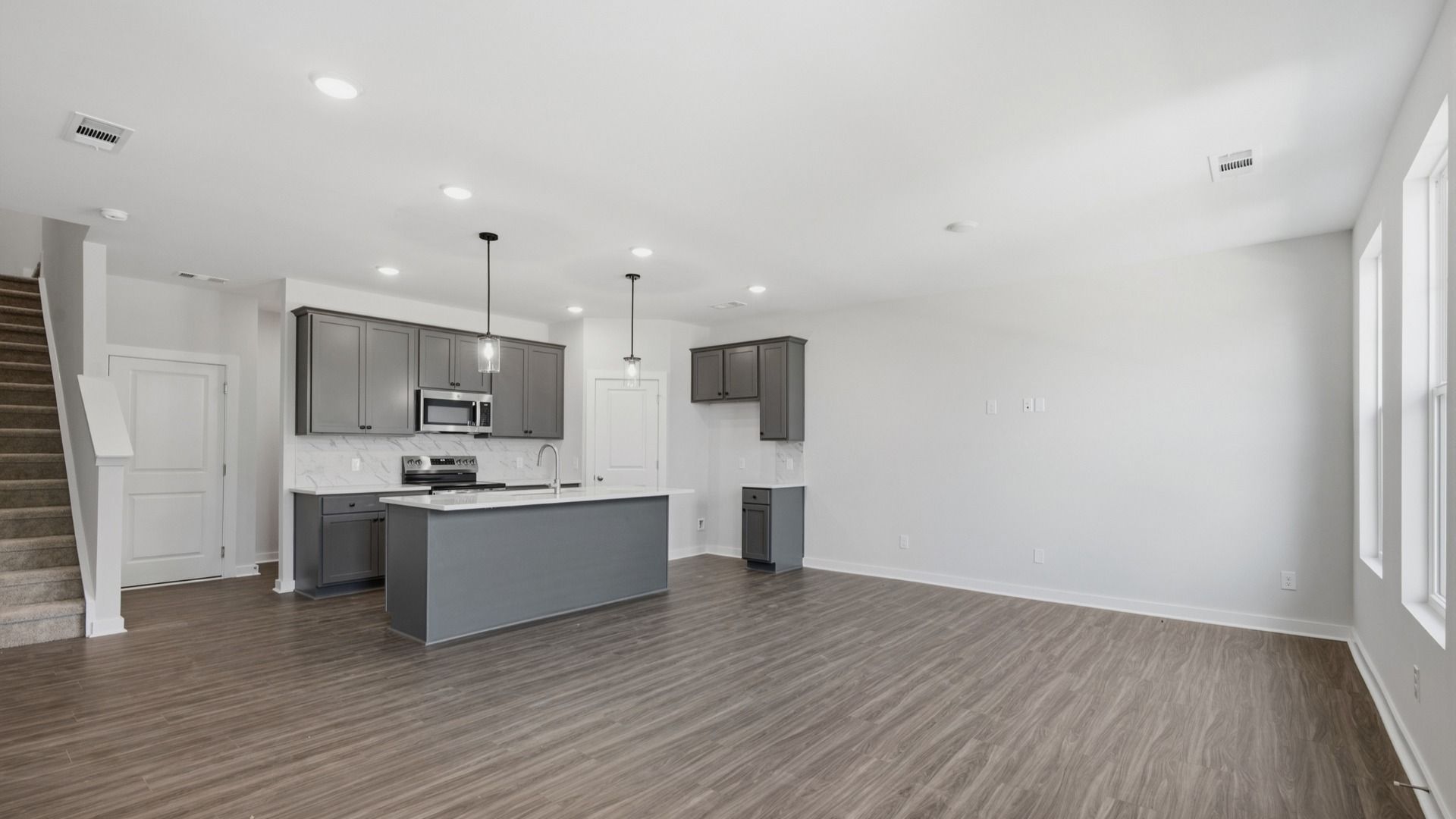 Kitchen with island and pantry door next to entryway