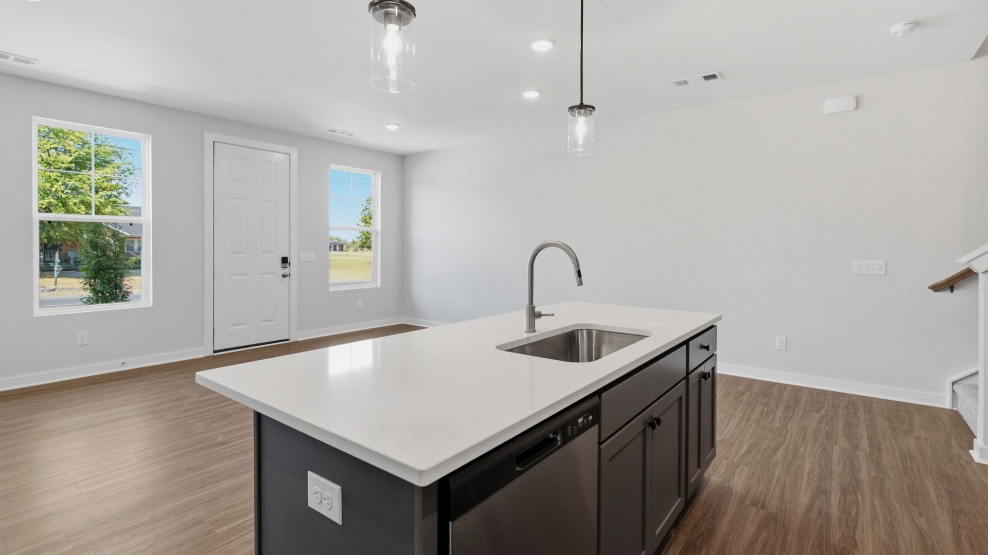 Kitchen island paired with sink and dishwasher with view of community