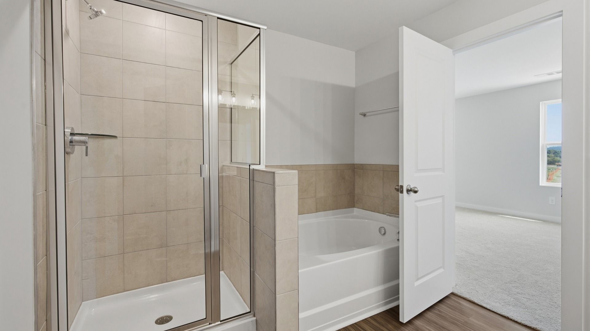 Shower and bathtub next to each other in primary bathroom