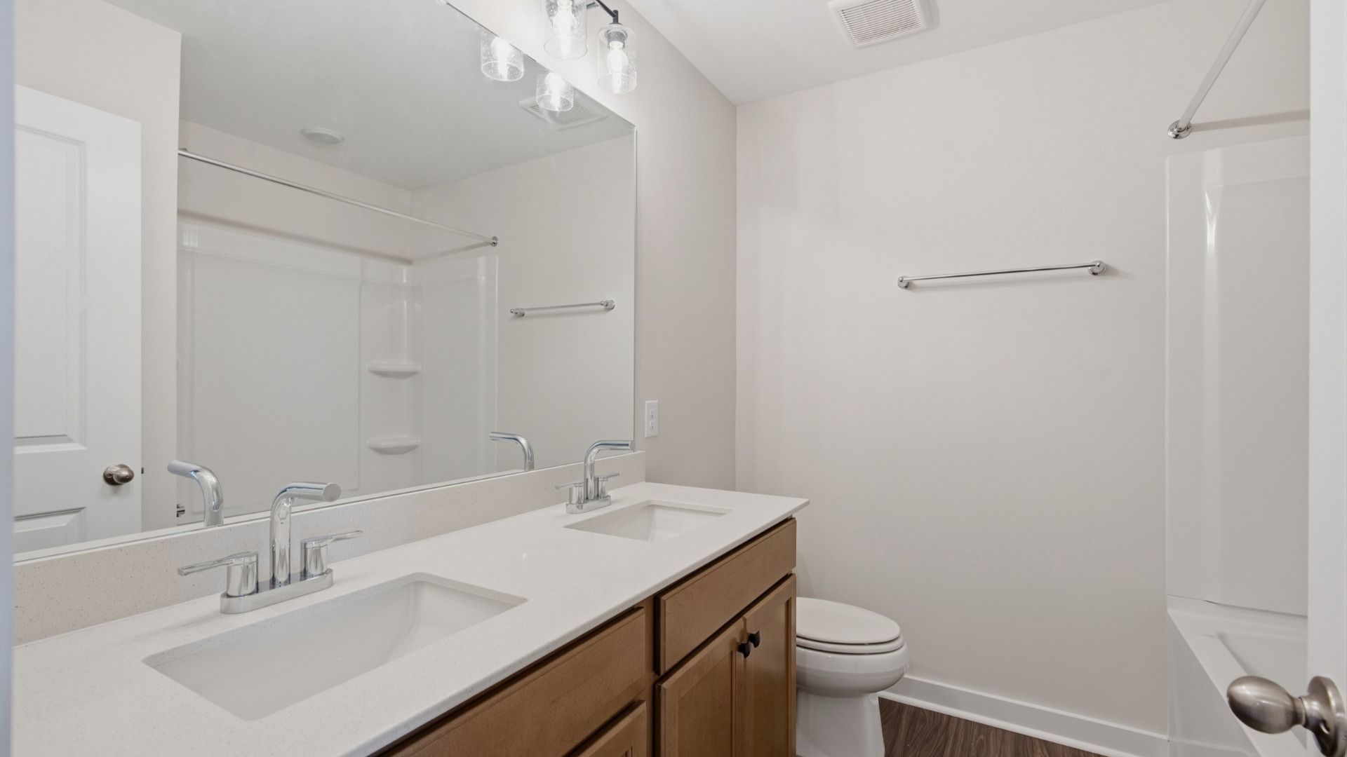 Bathroom with dual vanities across bathtub and shower