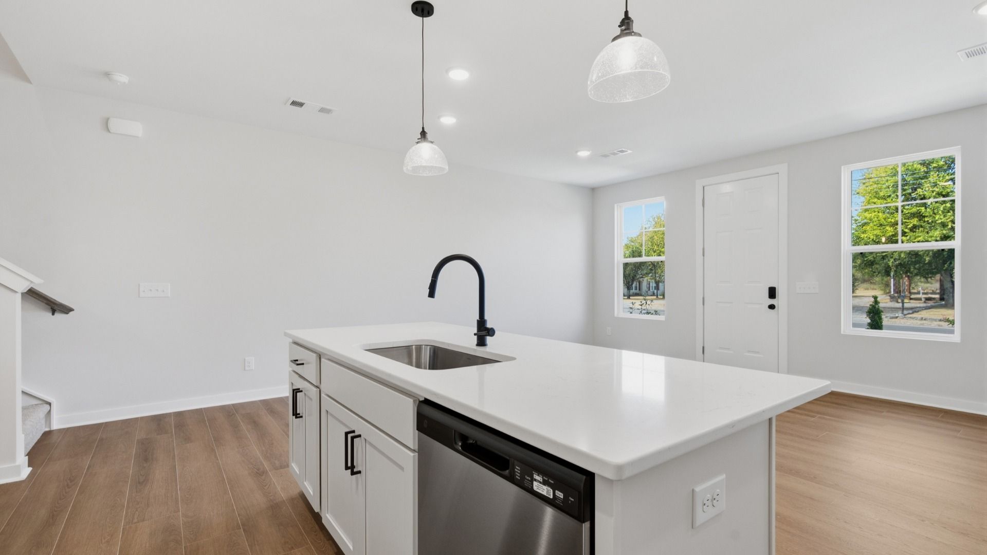 Kitchen island paired with sink and dishwasher with view of community