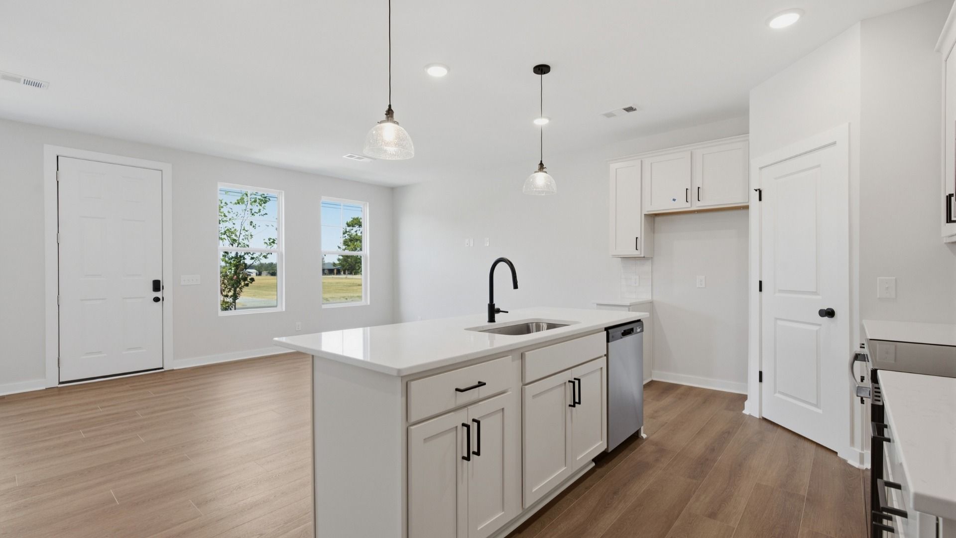 Kitchen island paired with sink and dishwasher with view of community