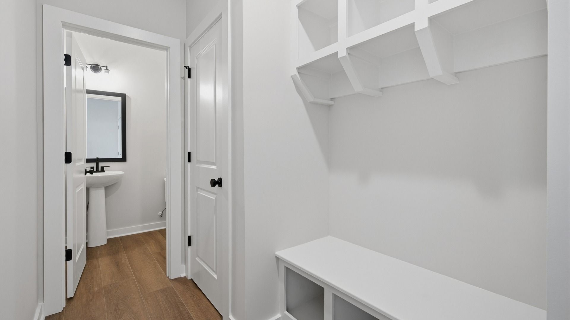 Hallway with white drop-zone and powder room
