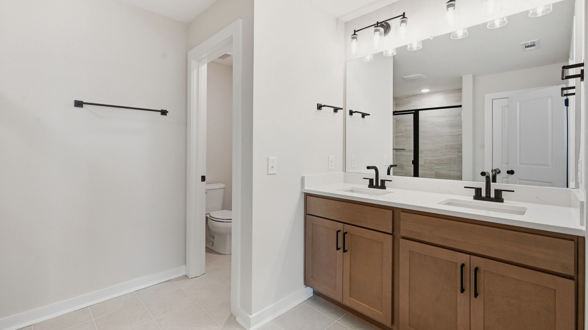 Water closet next to dual sinks