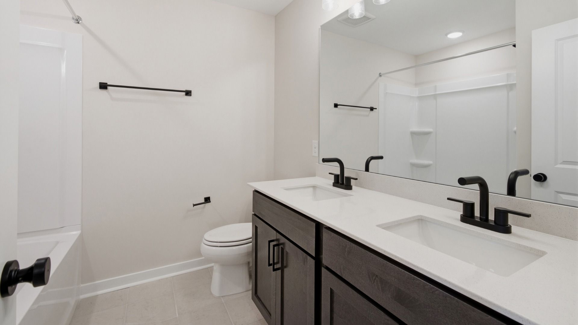 Bathroom with dual vanities across bathtub and shower