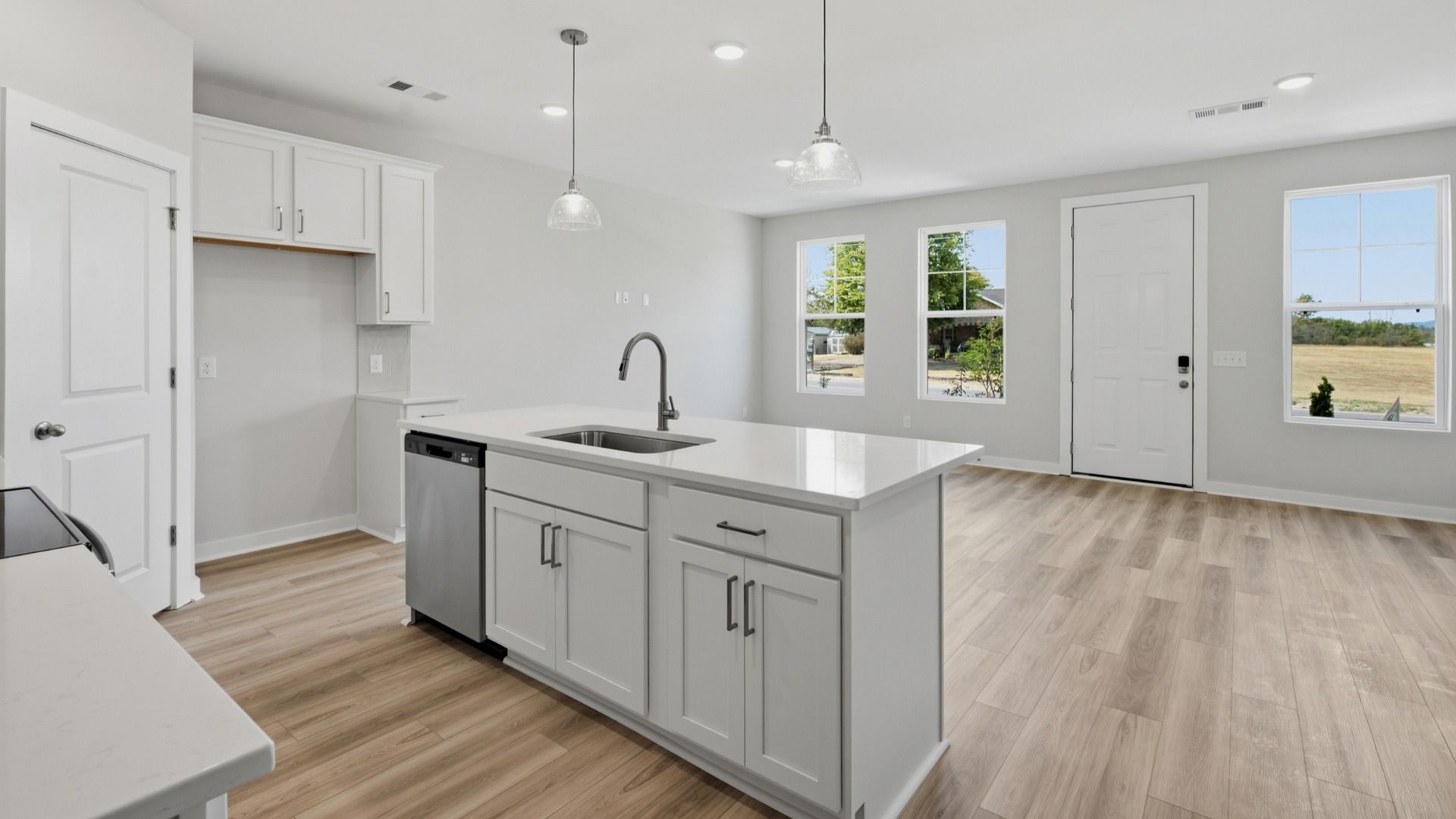 Kitchen island paired with sink and dishwasher with view of community
