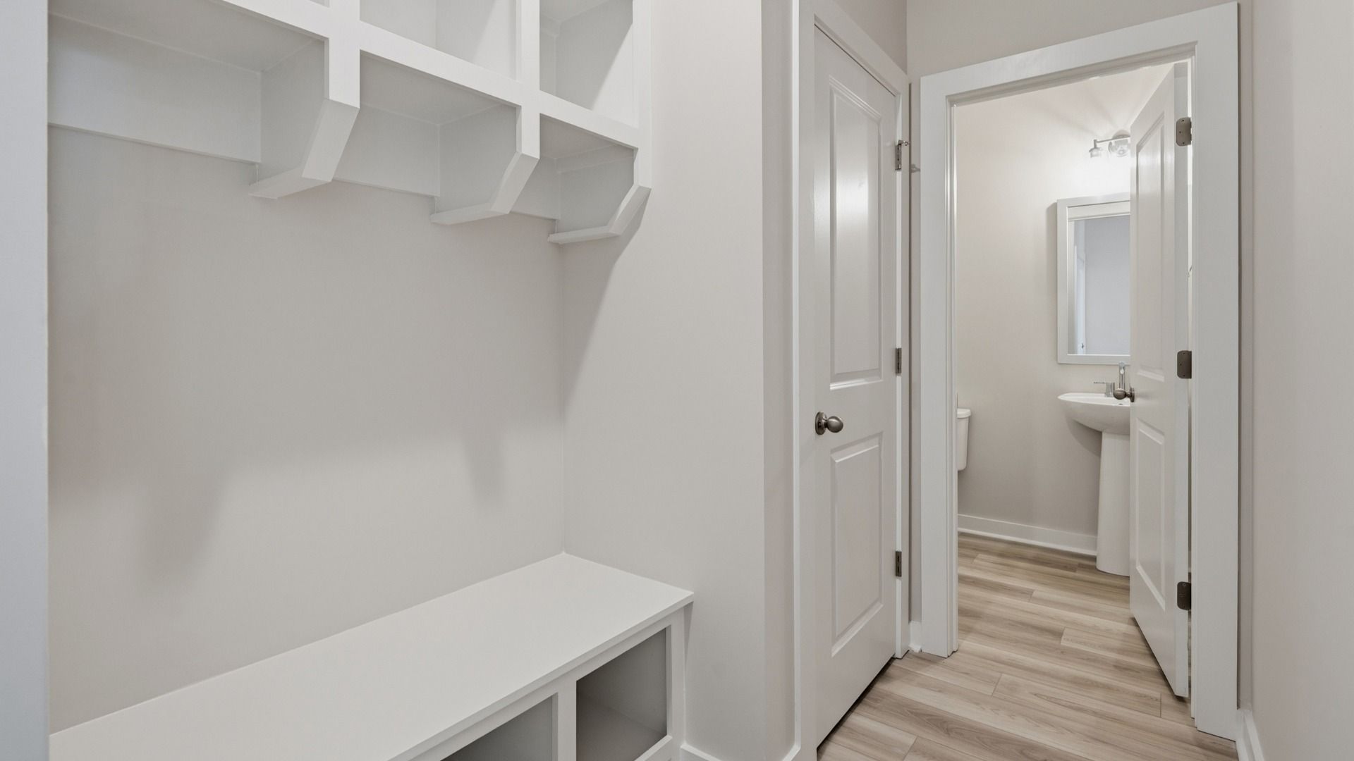 Hallway with white drop-zone and powder room