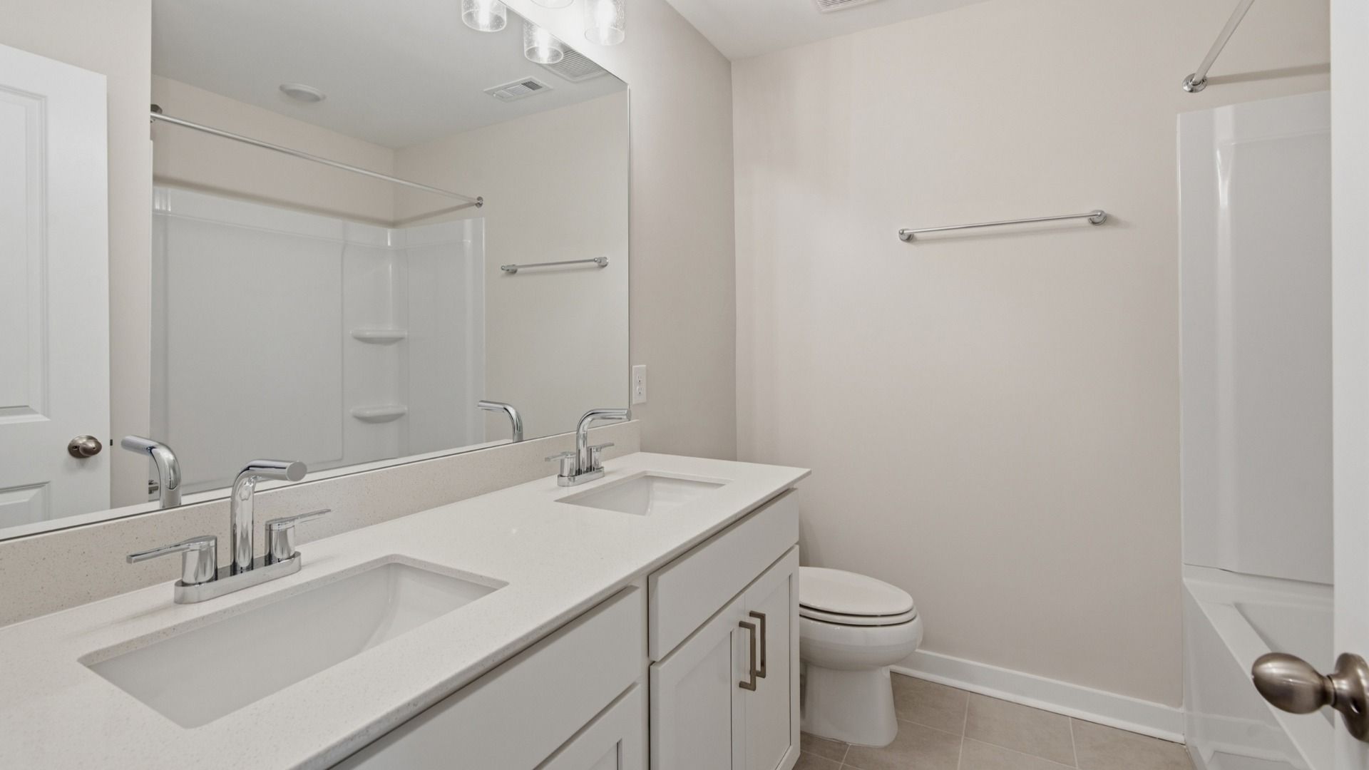 Bathroom with dual vanities across bathtub and shower