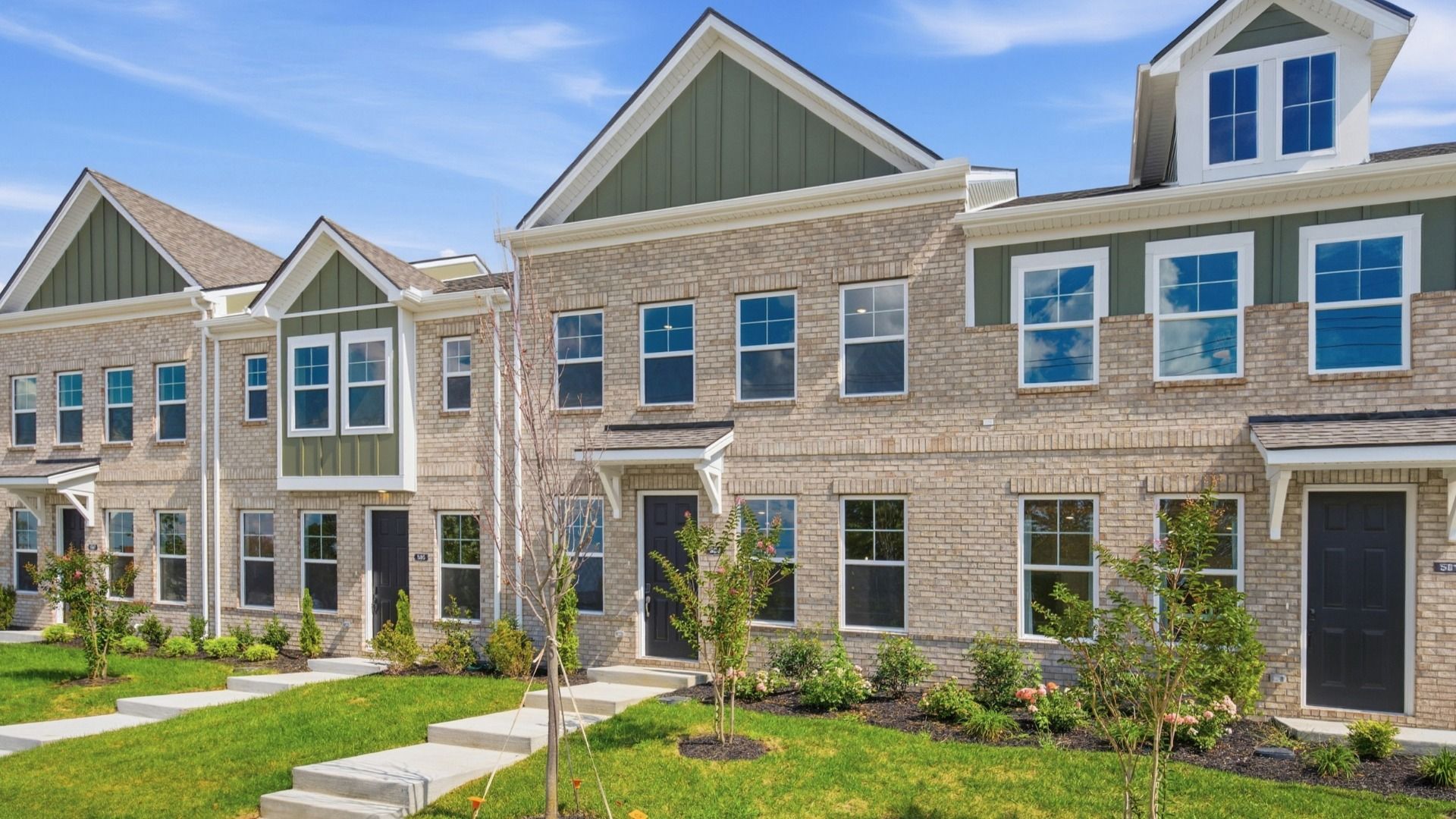 Front exterior with green accents of townhomes