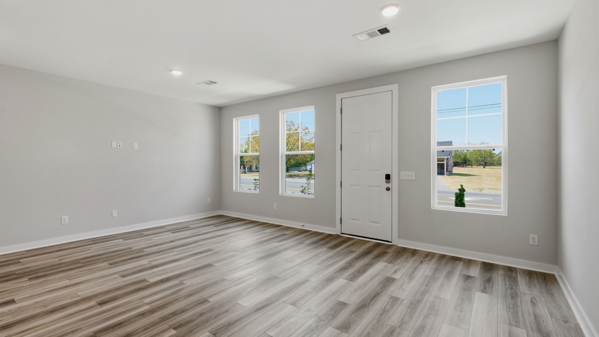 Spacious entrance with hardwood flooring and window lighting