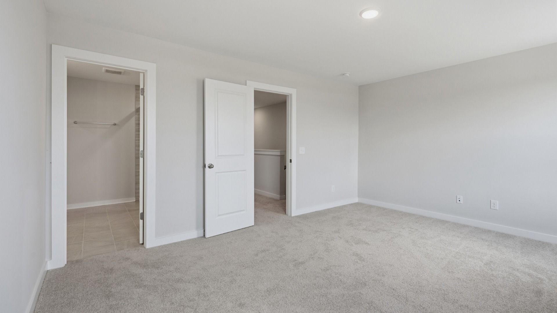 Spacious primary bedroom with connected bathroom and walk-in closet
