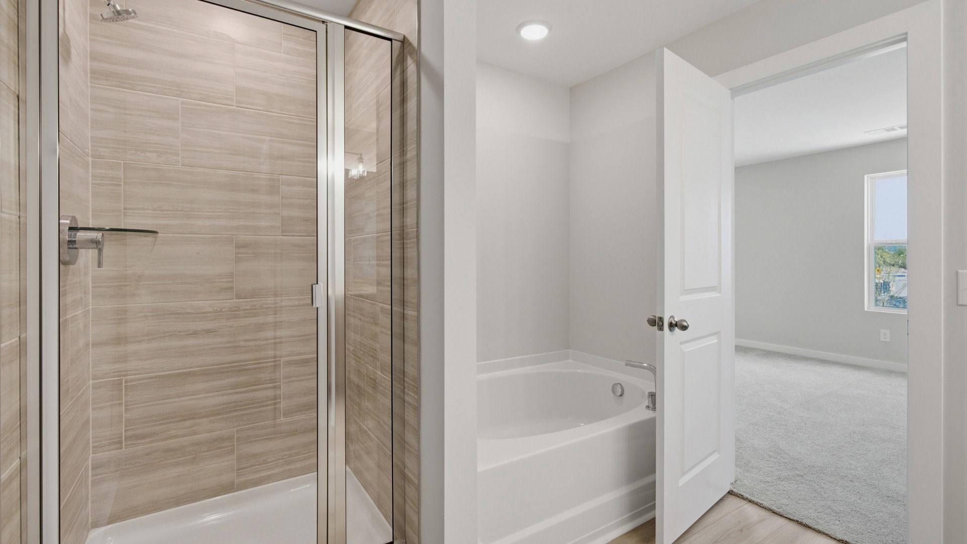 Bathtub next to shower in primary bathroom