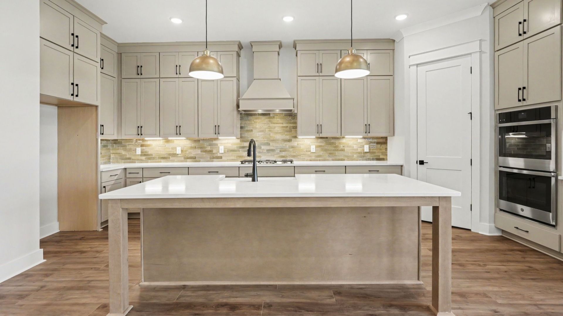 Island paired with sink and dishwasher under hanging lights