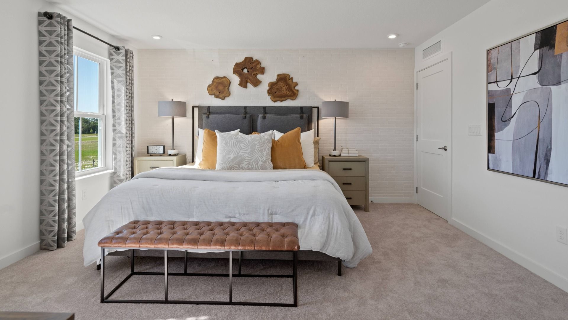 Carpeted primary suite with large window in a DRB Home Clementine model at the Trinity Place community.