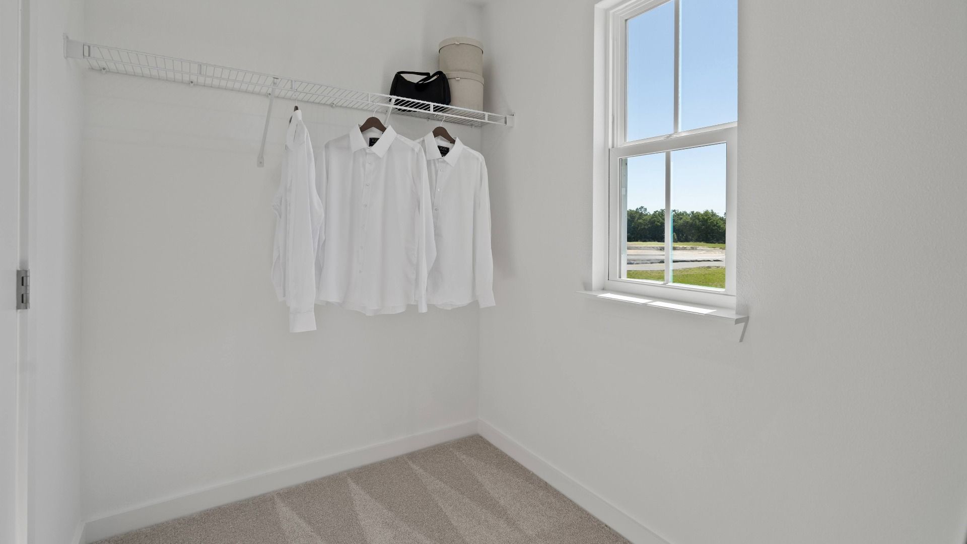 Primary suite walk-in closet with window in a DRB Home Clementine model at the Trinity Place community.