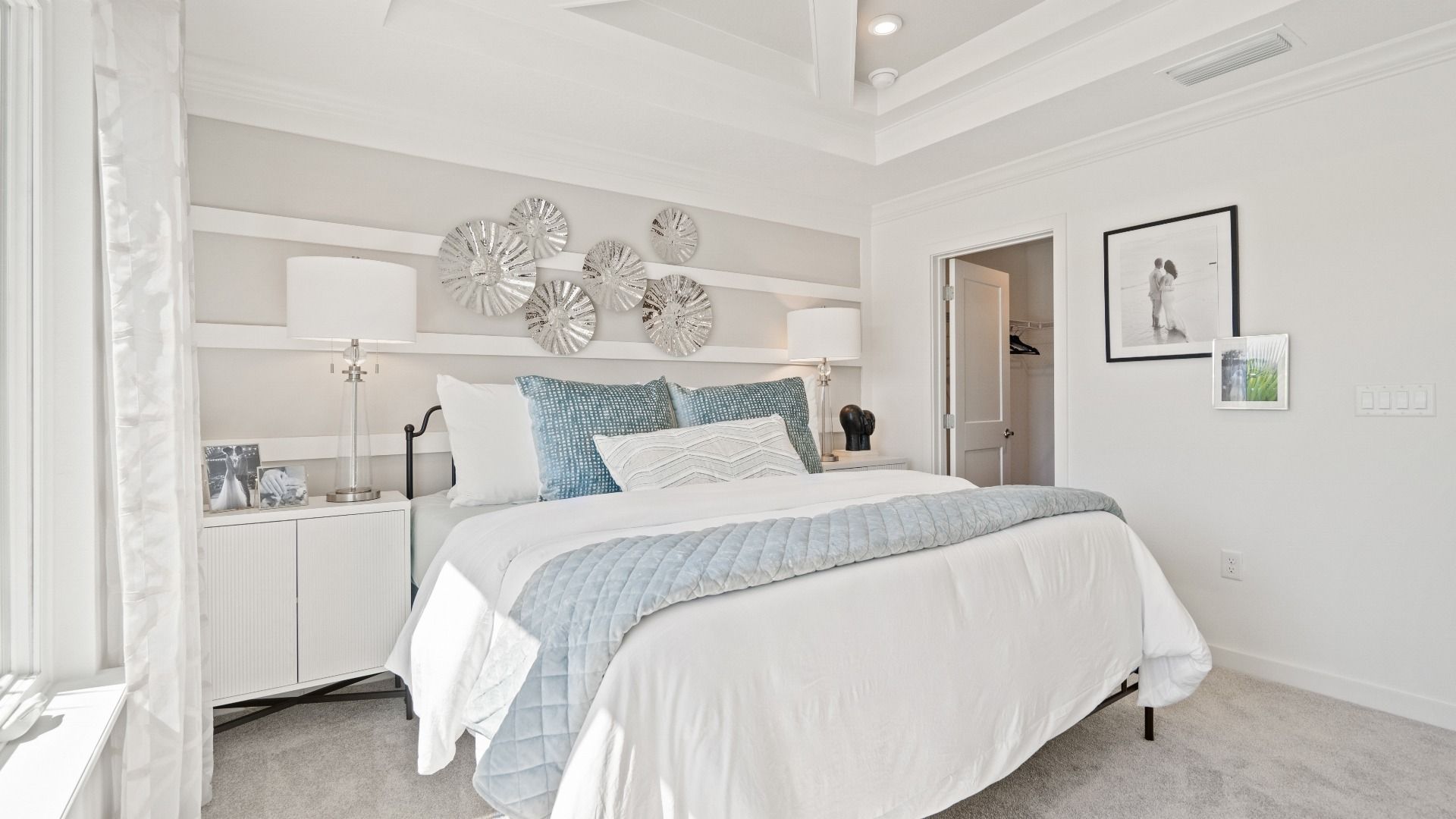 Carpeted primary bedroom with tray ceiling in a DRB Homes Ambersweet model at the Trinity Place community.