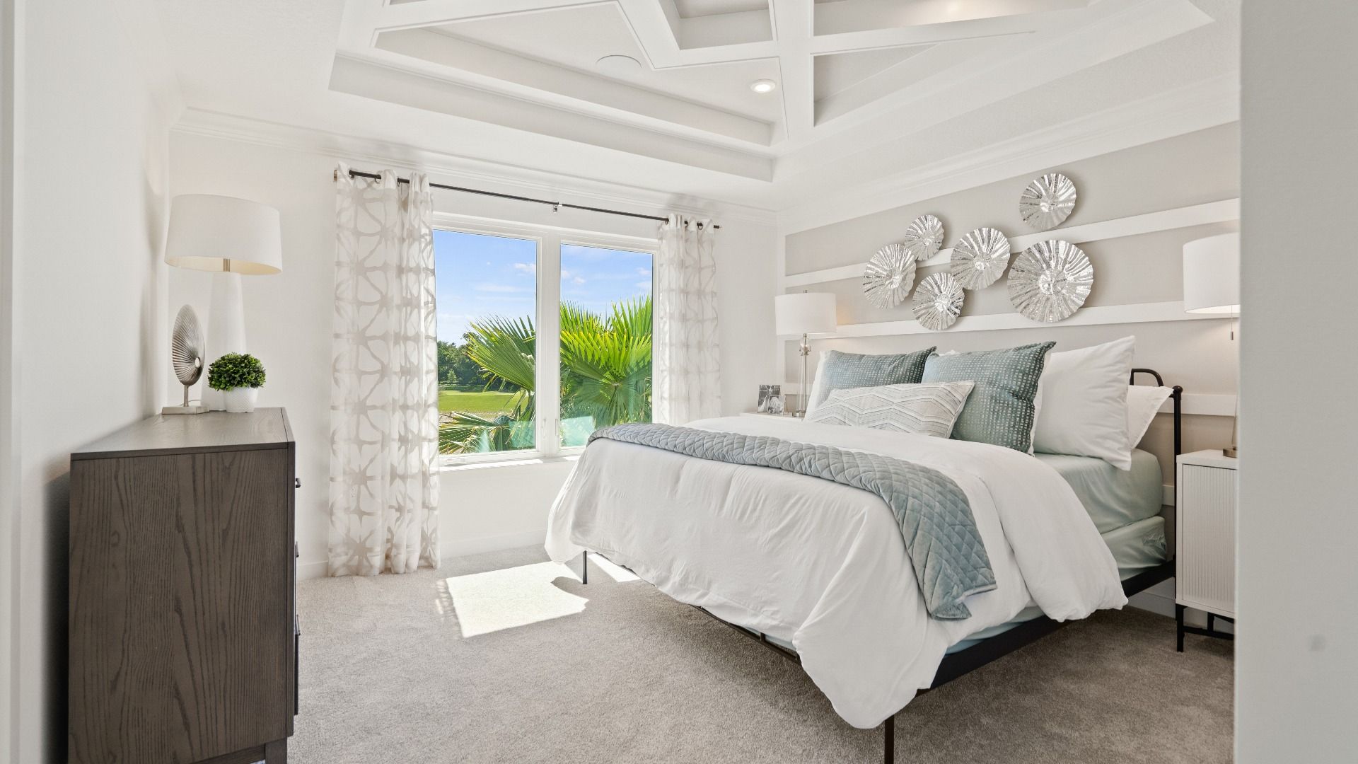 Primary bedroom with tray ceiling and large double window in a DRB Homes Ambersweet model at the Trinity Place community.