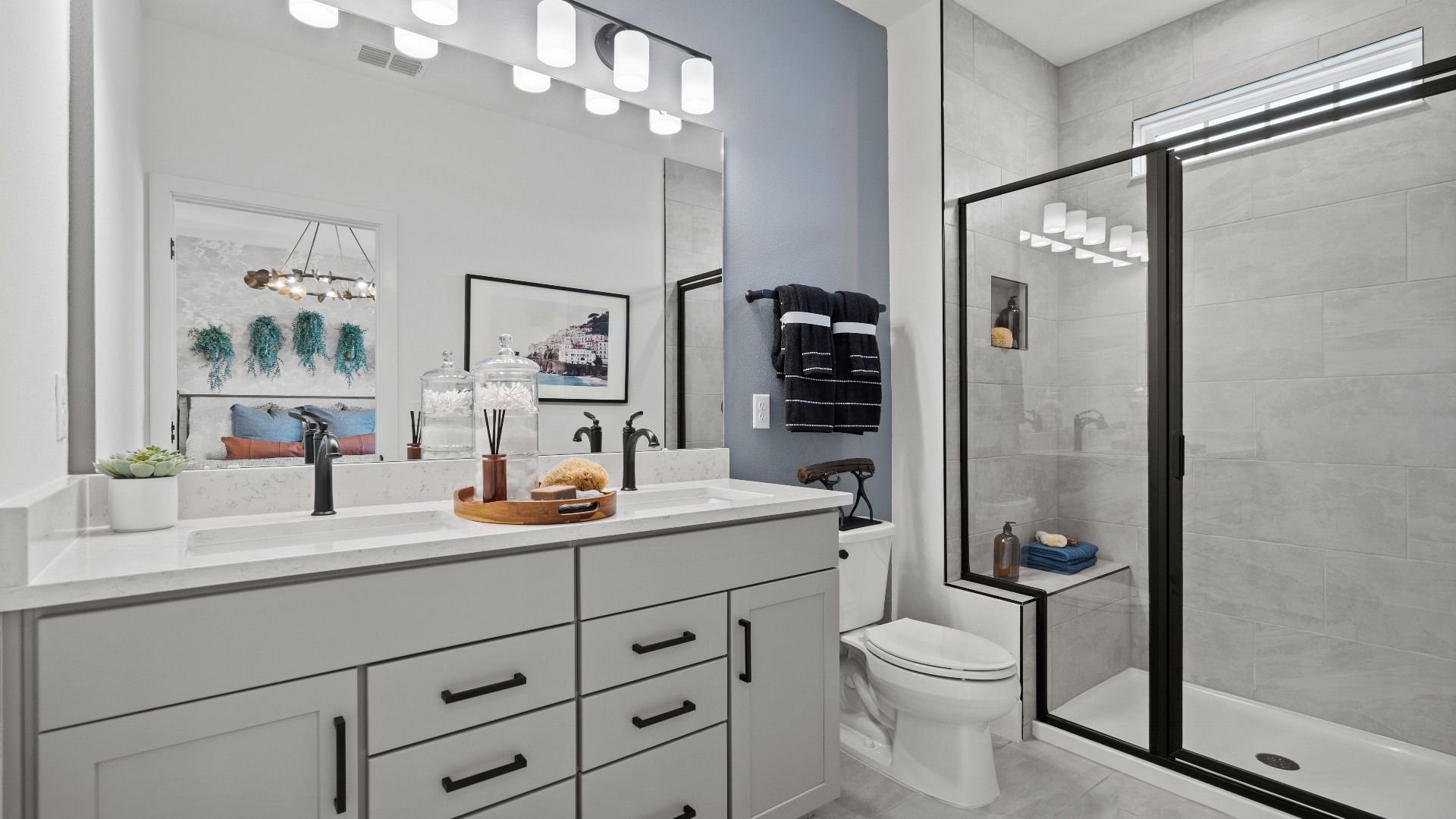 The primary suite bathroom at Parkview at Hamlin by DRB Homes offers a spa-like retreat with dual sinks and a walk-in shower