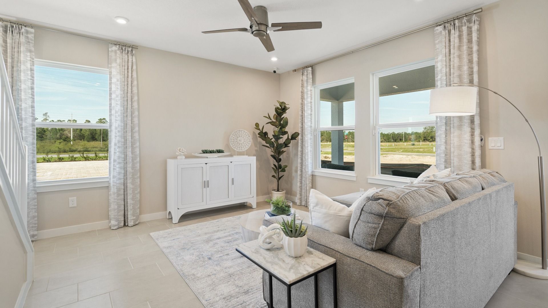 Cyrene at Harmony by DRB Homes features a spacious living room with three large windows—filling the space with natural light.