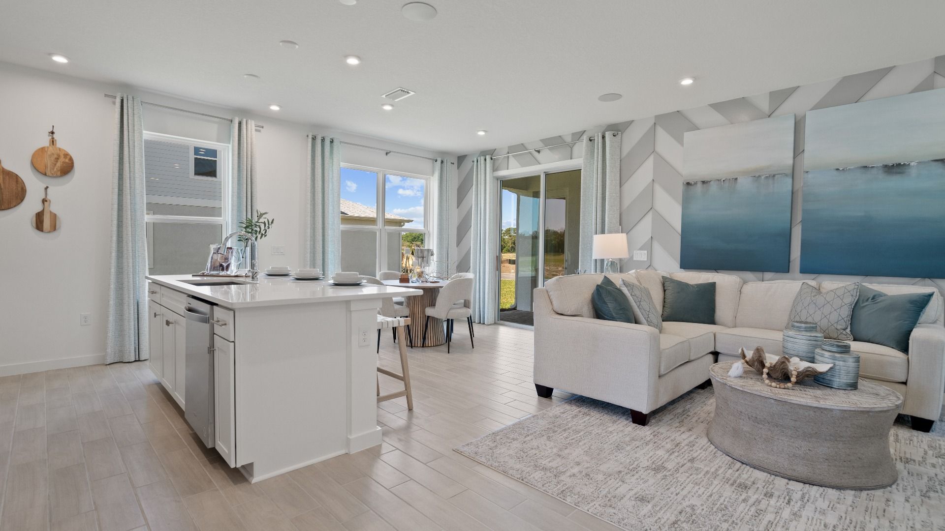 Open kitchen and living space at DRB Homes with large windows for natural light