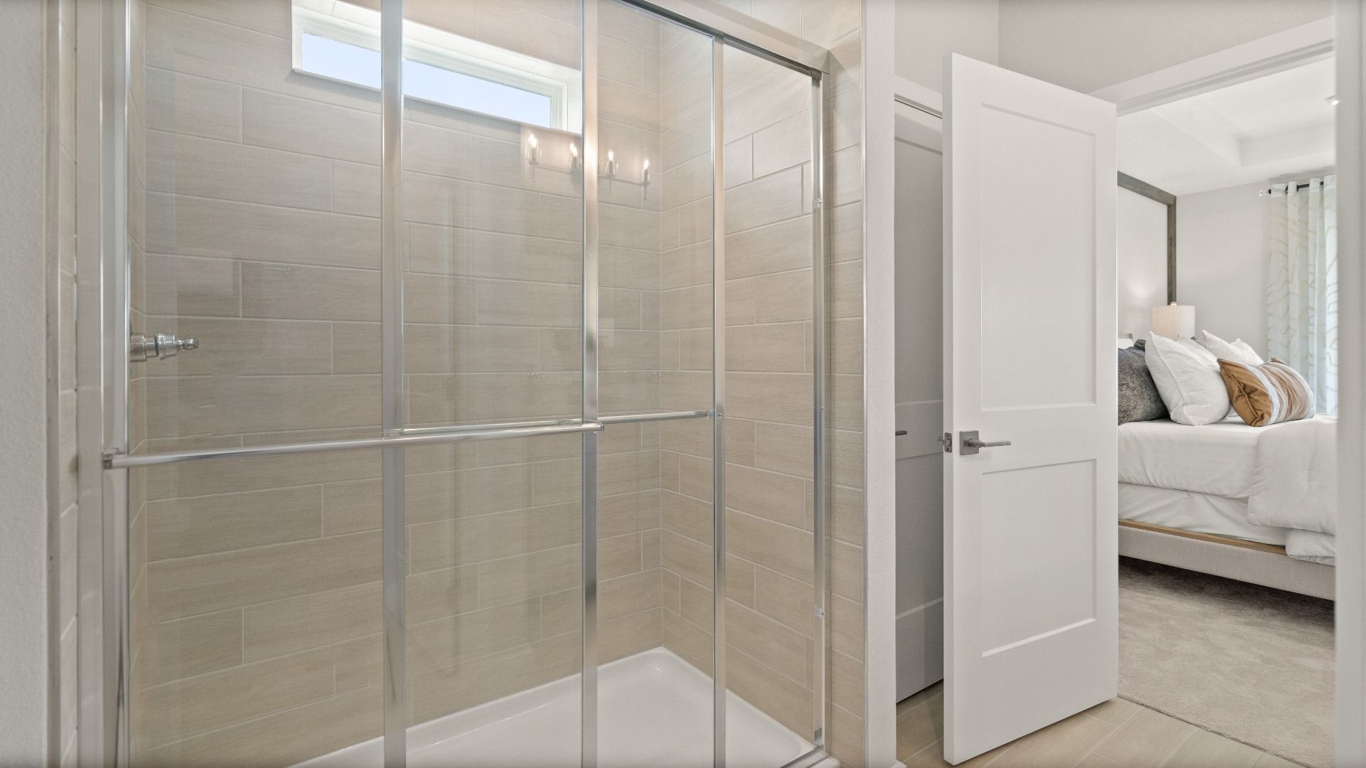 Glass walk-in shower with tile in the owner’s suite of the Jupiter Model by DRB Homes at Grasslands West in Lakeland, FL.