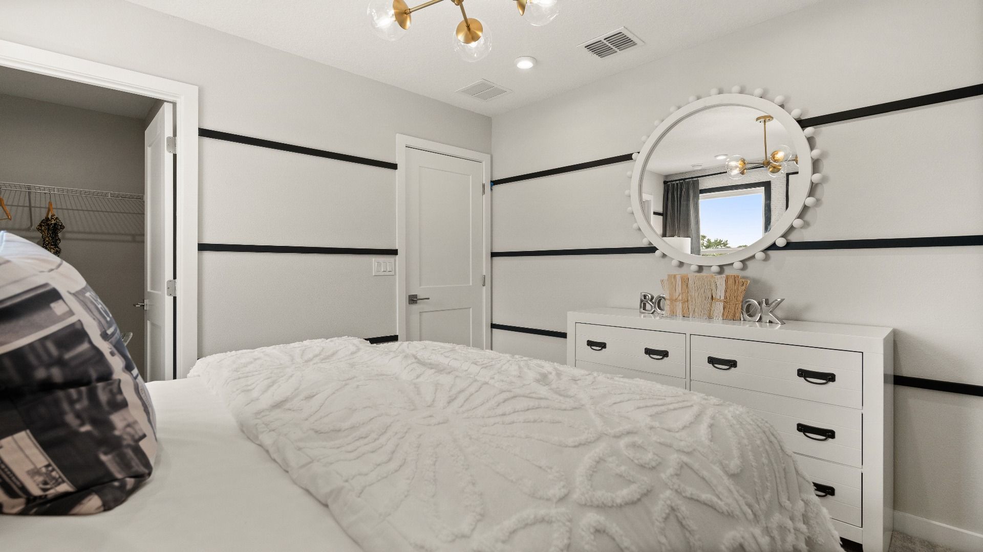 Bright secondary bedroom with walk-in closet, accent wall, and modern finishes in the Jupiter Model at Grasslands West.