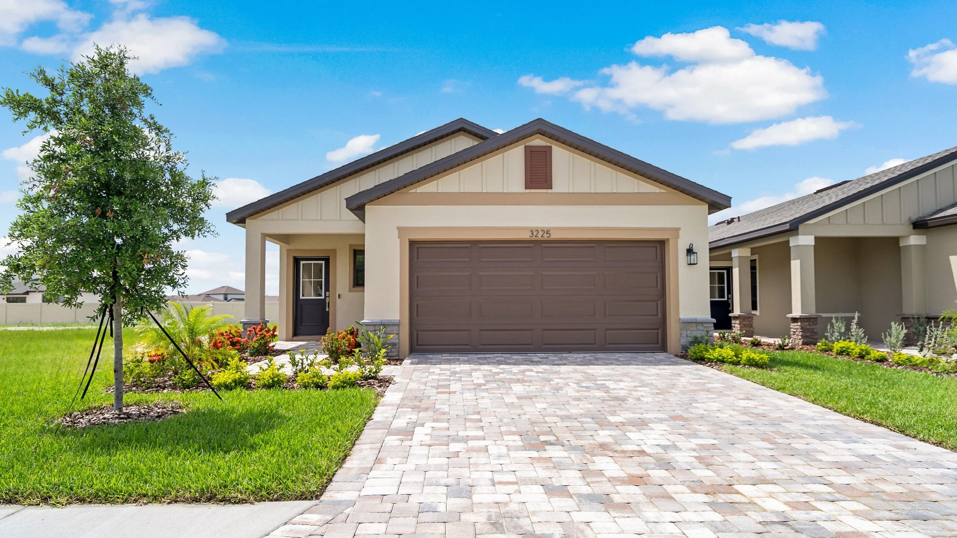 The Atlantic at Grasslands West,  new build single-story home with a 2 car garage and paver driveway in Lakeland FL.