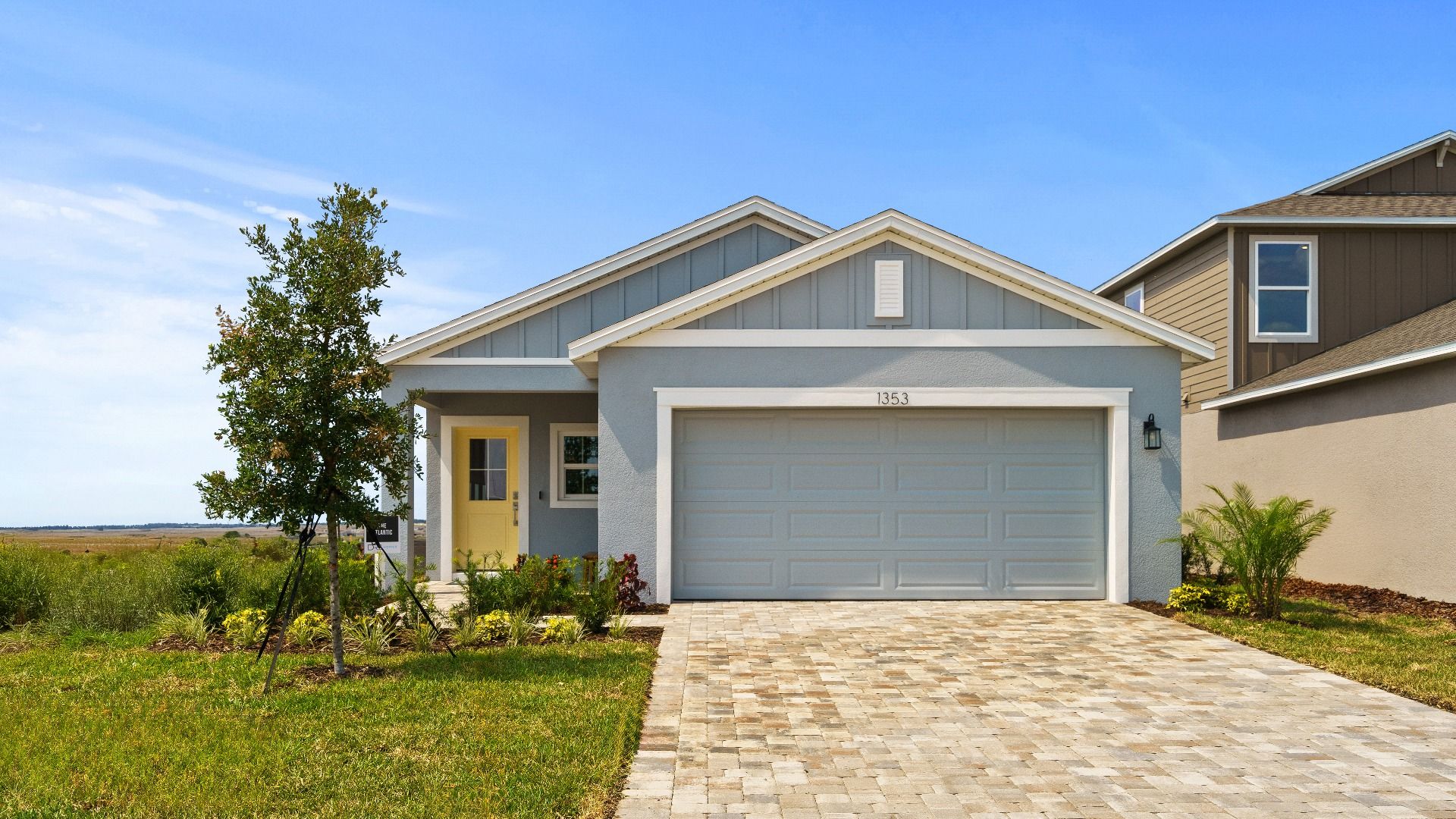 Front exterior of The Atlantic by DRB Homes at Hamilton Bluff featuring a 2-car garage, gable roofline, and paver driveway.