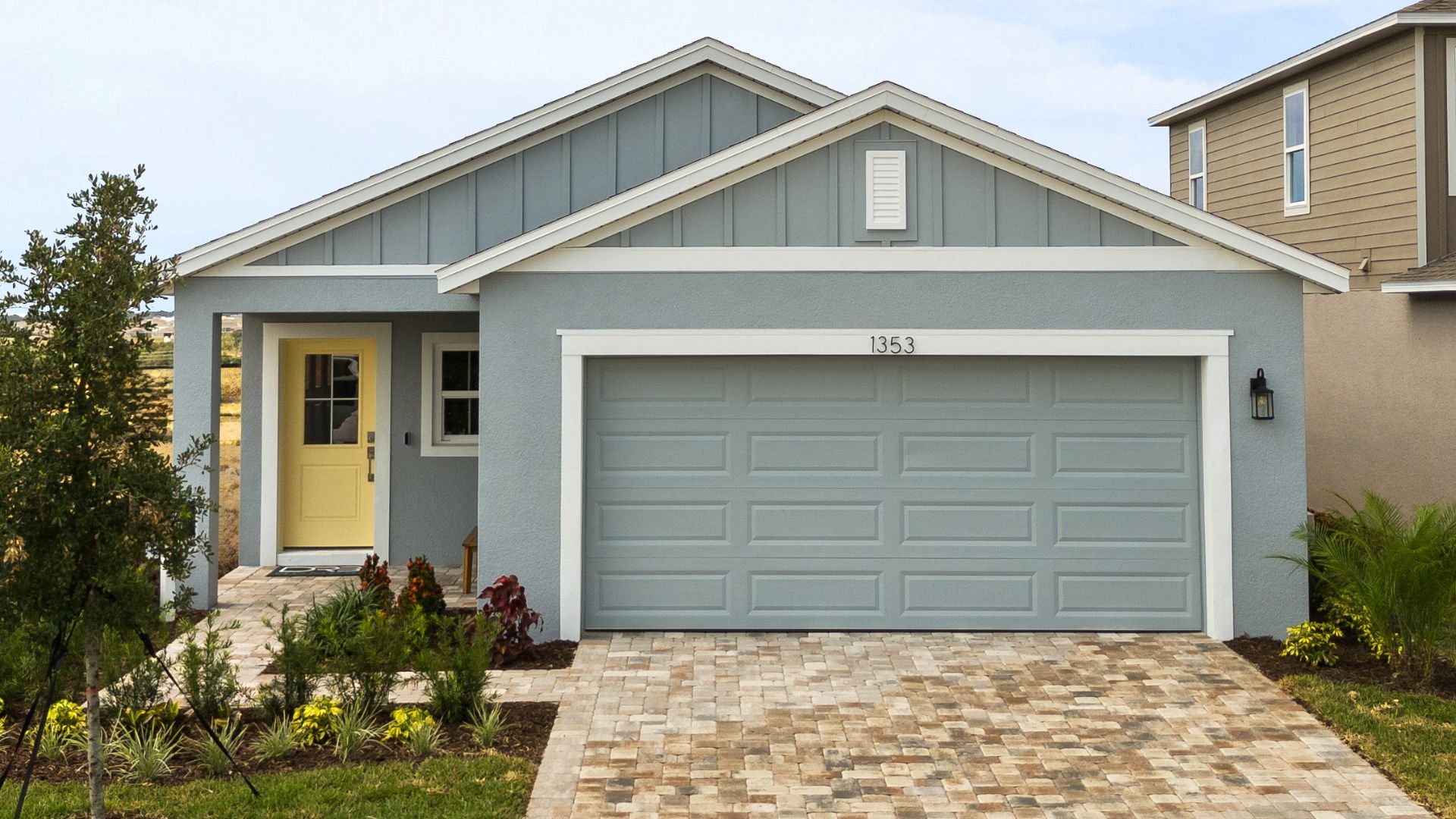 This view of The Atlantic at Hamilton Bluff highlights the charming covered porch, 2-car garage, and paved driveway.