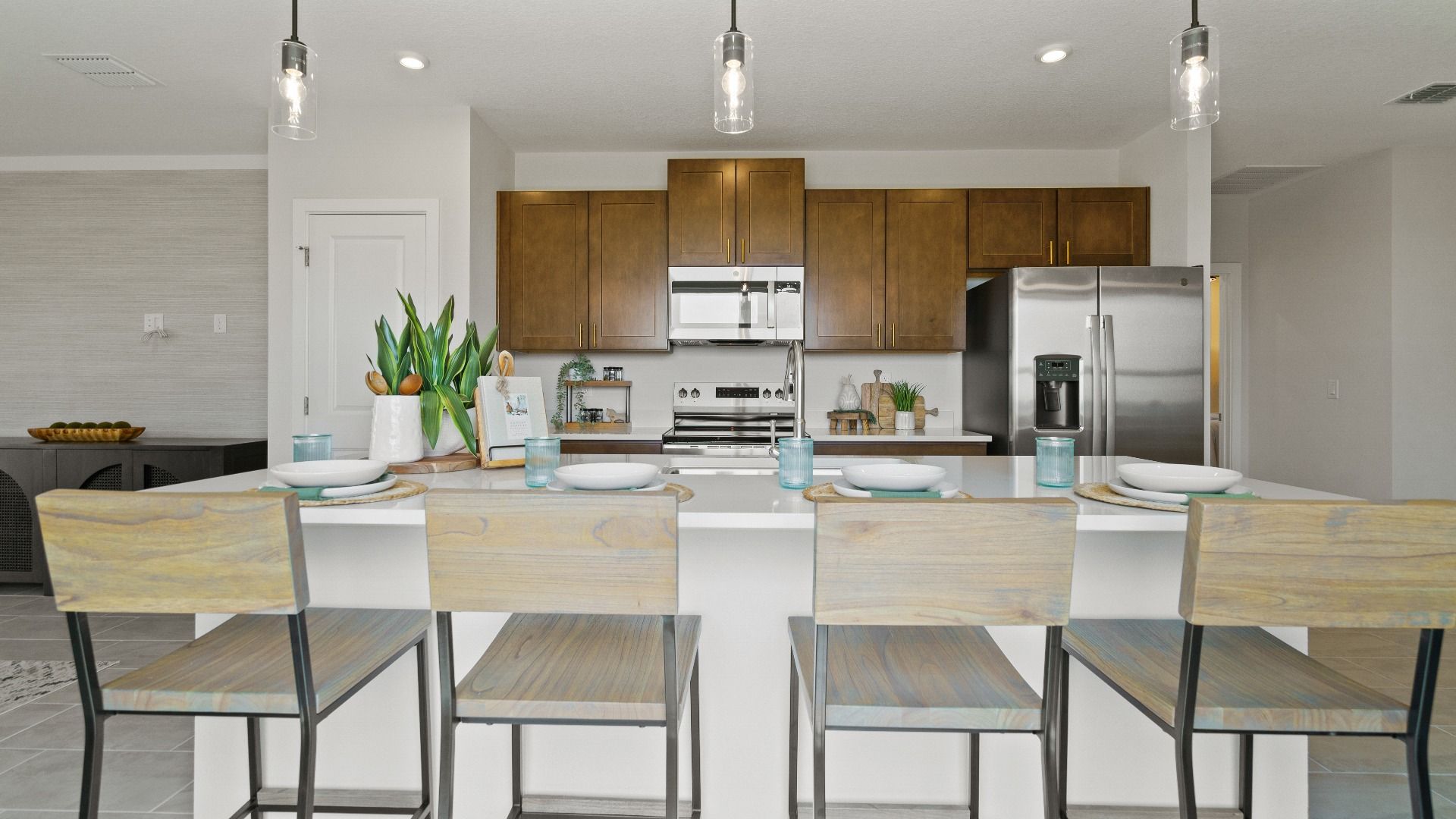 Spacious kitchen at Hamilton Bluff with island seating, wood cabinetry, and stainless steel appliances.