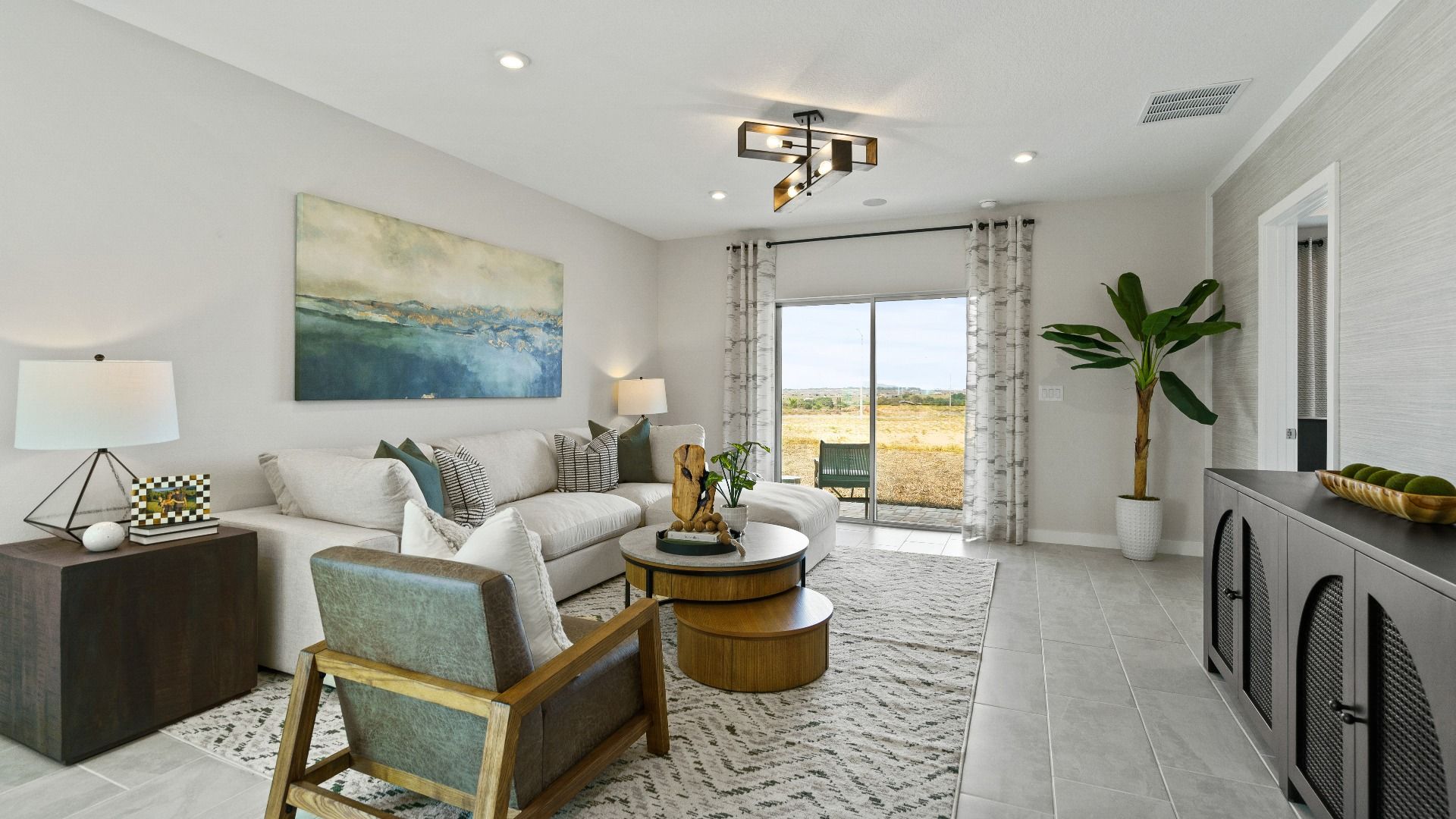 Spacious living room at Hamilton Bluff featuring backyard views, soft-tone furnishings, and plenty of natural light.