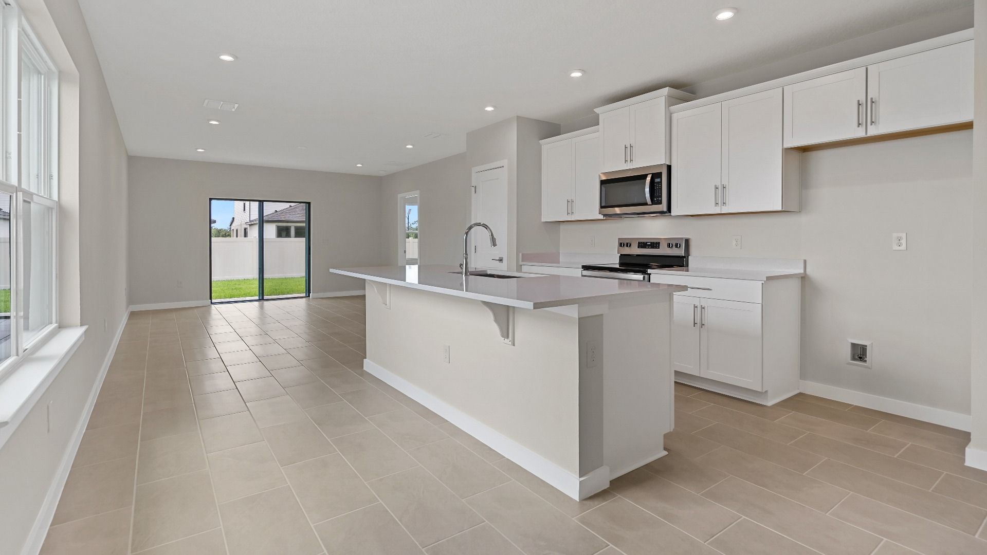 The Atlantic by DRB Homes offers a bright open-concept kitchen with island seating—perfect for entertaining in Lakeland, FL.