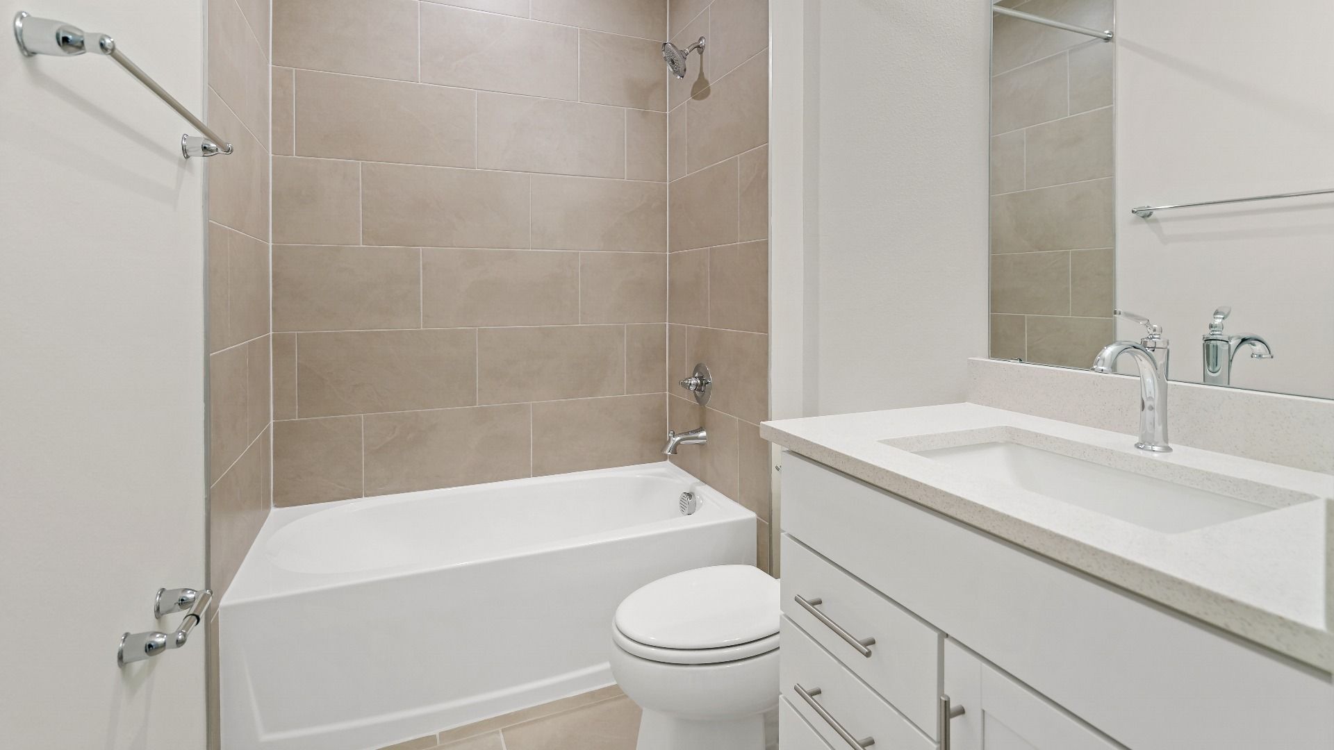 The Atlantic’s guest bath features a tiled tub-shower combo, sleek white vanity, and contemporary finishes in Lakeland, FL.