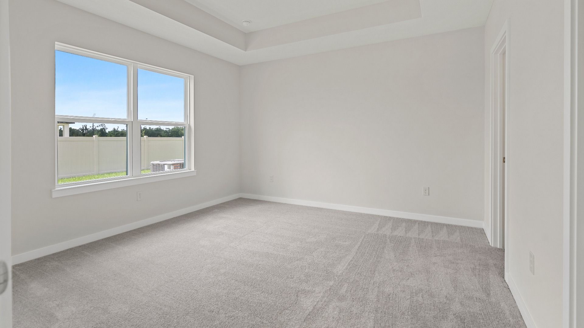 This guest bedroom in The Atlantic offers comfort and style with soft carpet, bright natural light, and a peaceful layout.