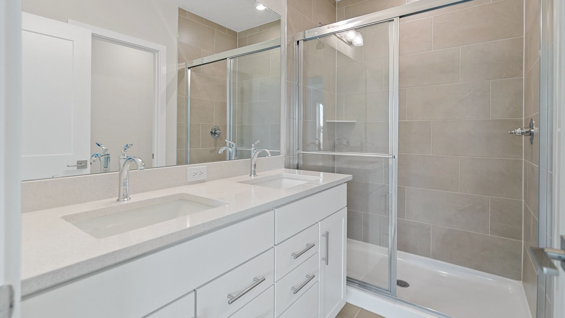 The Atlantic’s owner’s bath includes dual sinks, a spacious vanity, and a tiled walk-in shower with modern glass enclosure.