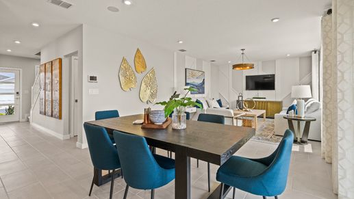 Open dining and living space in The Highbourne at Hamilton Bluff featuring bold seating, tile floors, and natural light.