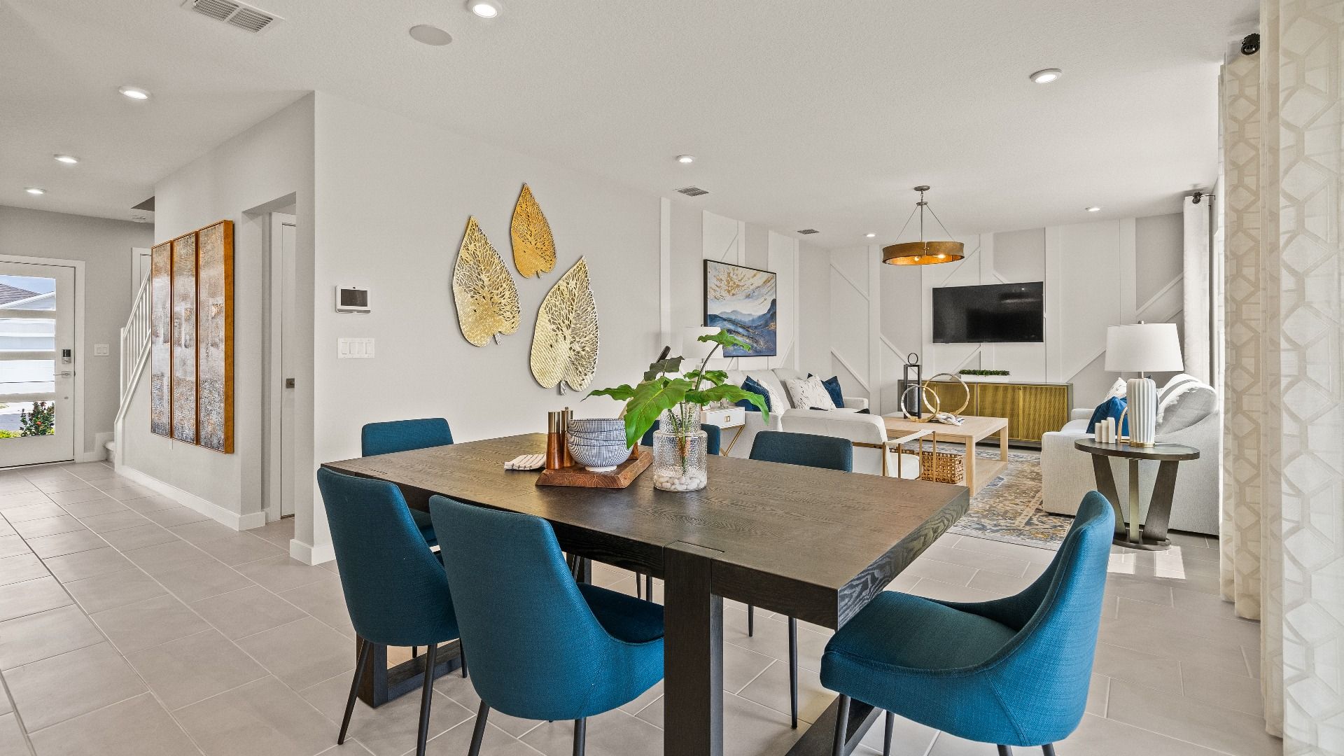Open dining and living space in The Highbourne at Hamilton Bluff featuring bold seating, tile floors, and natural light.
