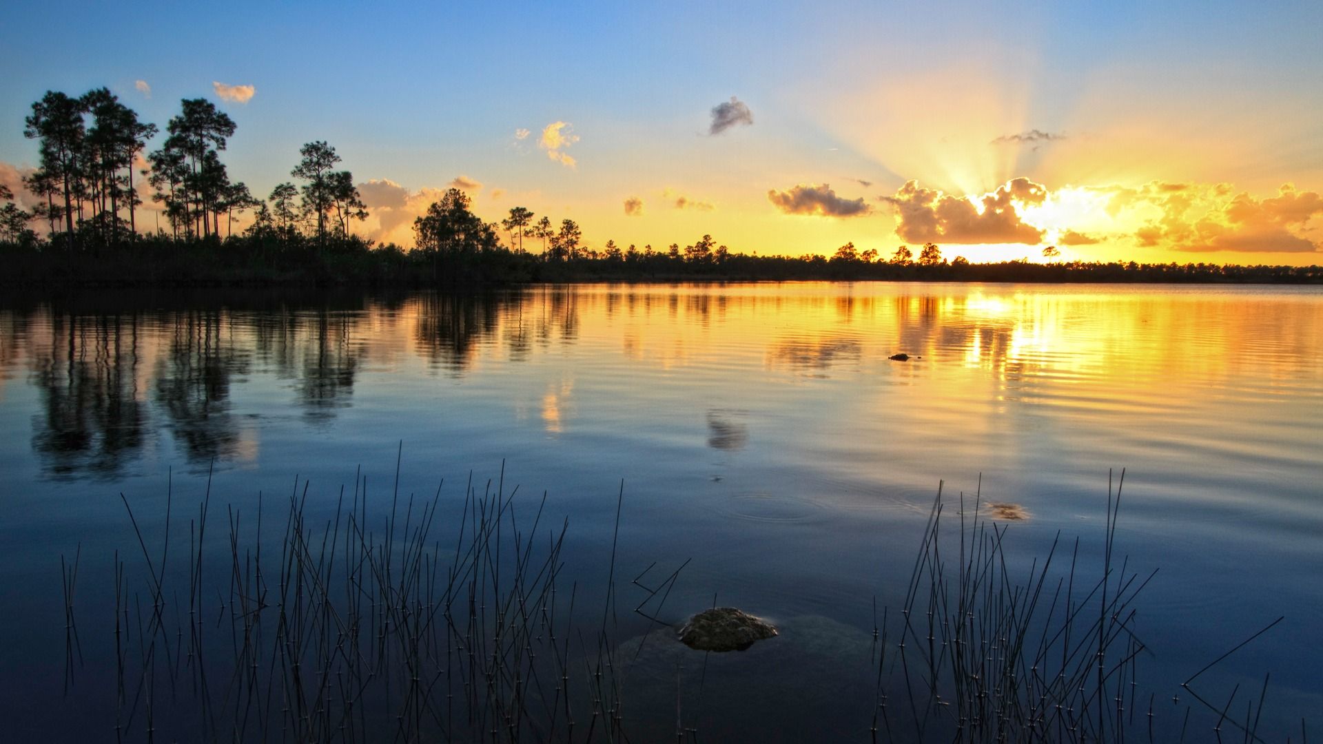 Scenic lake view at sunset with vibrant skies reflecting on the water—capturing the beauty of nature and peaceful evenings.