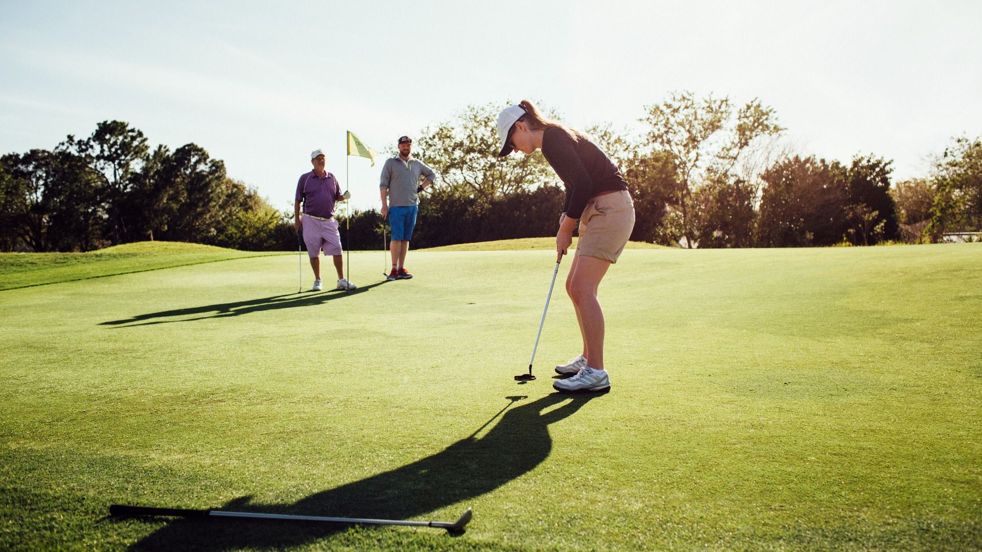 Group enjoying a round of golf on a sunny, scenic course.