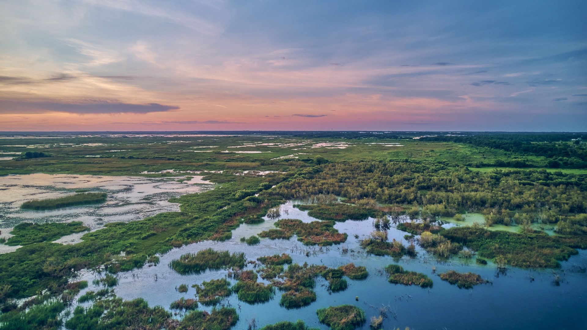 Panoramic view of a serene lake surrounded by open grasslands—capturing natural beauty and wide-open scenic landscapes.